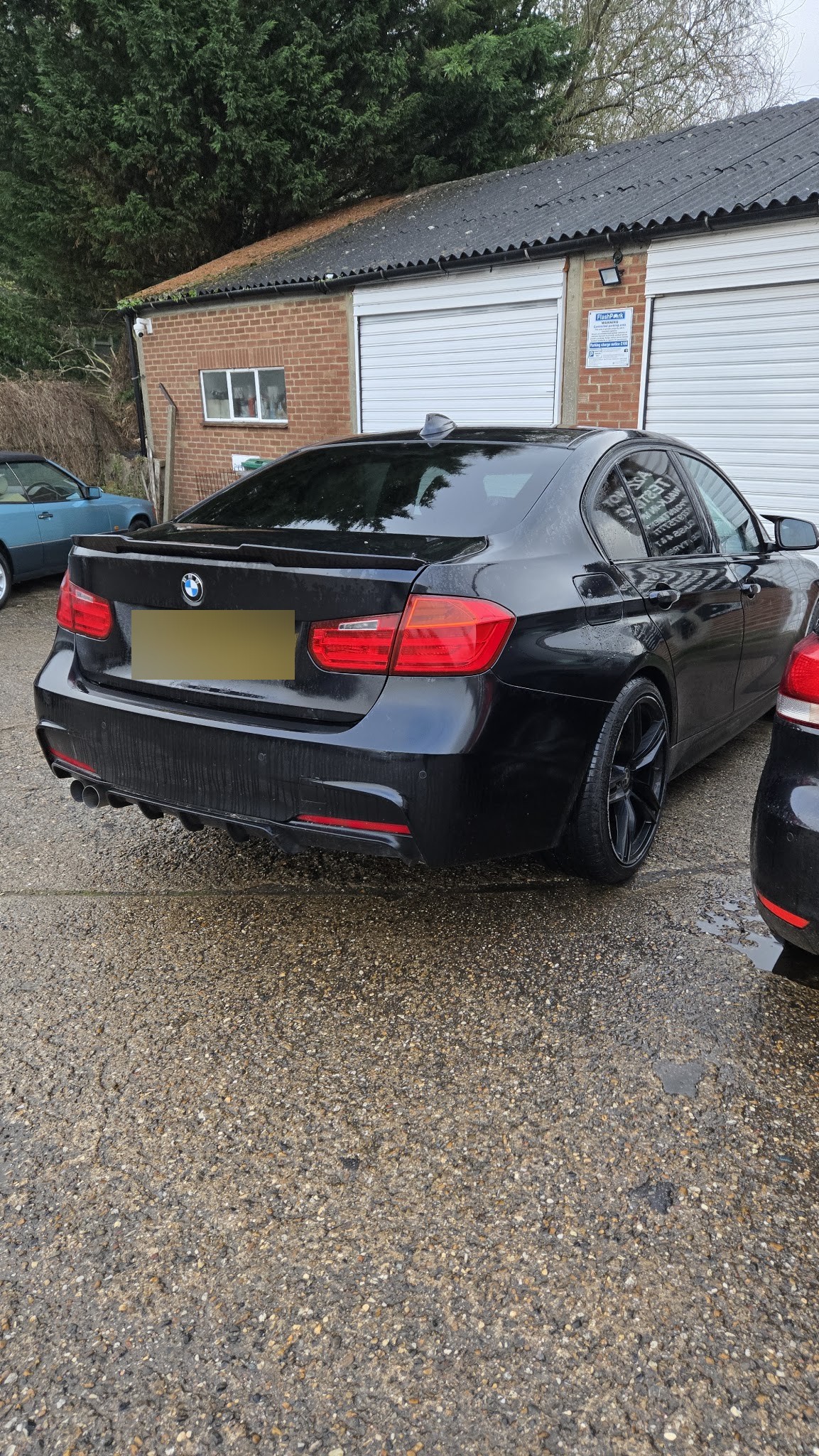 A customer's BMW in the yard outside the workshop roller doors